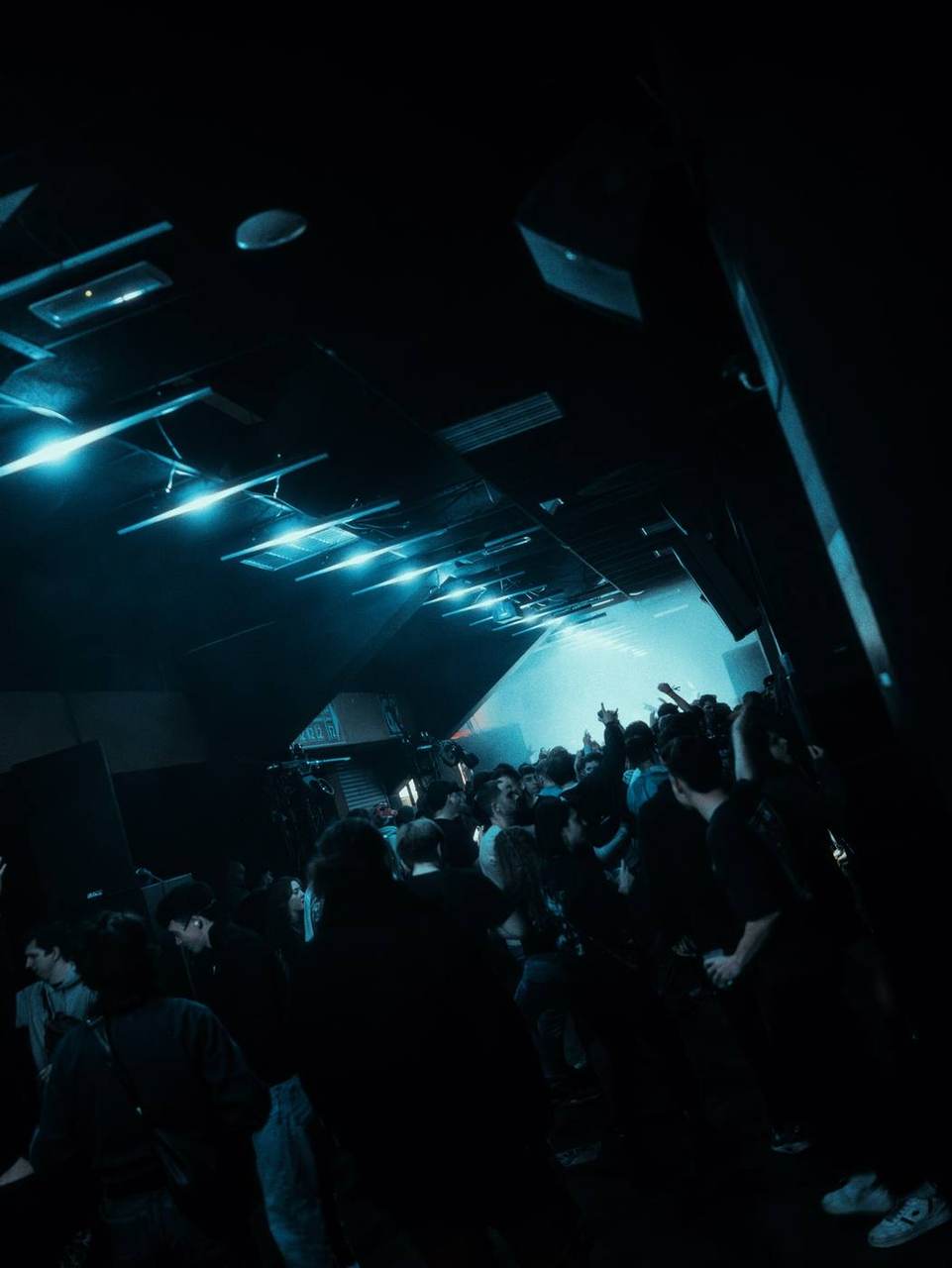 Barres LED bleues au plafond, public dans la fumée